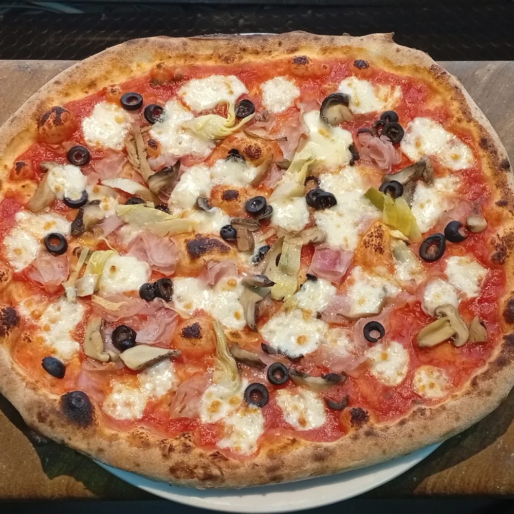 Pizza Capricciosa con prosciutto cotto, funghi, olive nere e carciofi